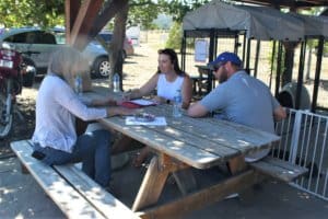 Mary Luton discusses puppy adoption packet with adopters
