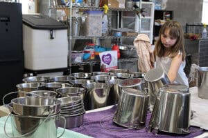 Rescue Ranch volunteer, young Piper drying water buckets during Lava Fire