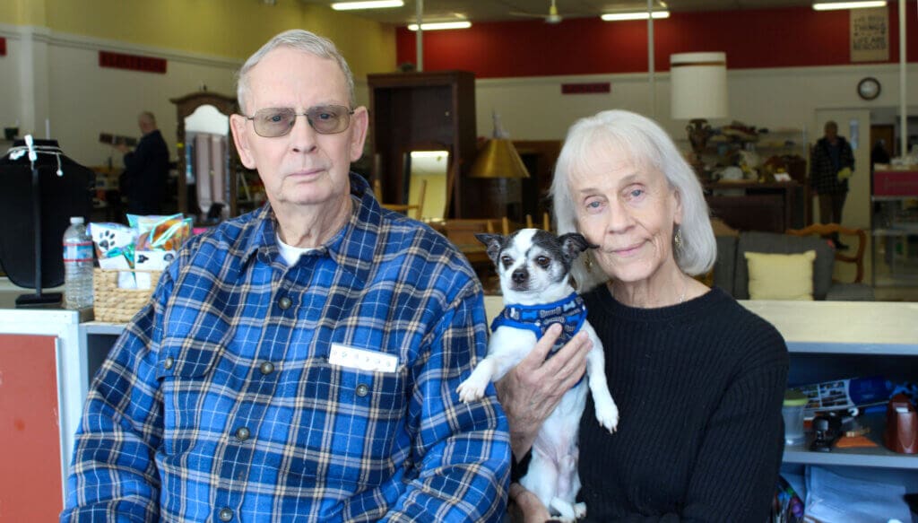 Rescue Ranch volunteers, Sue and Bill Doron with Maverick behind thrift store counter