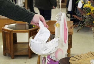 Thrift Store, hand putting receipt in glass bowl for prize drawing