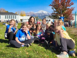 outdoor group shot of children_teacher_and puppies on school yard grass