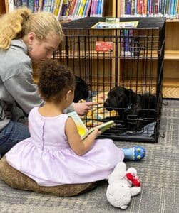 Puppies puppies puppies_Meghan and toddler in lavender dress reading to pup