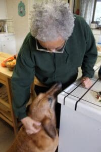 Dog Rescuers Colette giving Woody treats in the kitchen